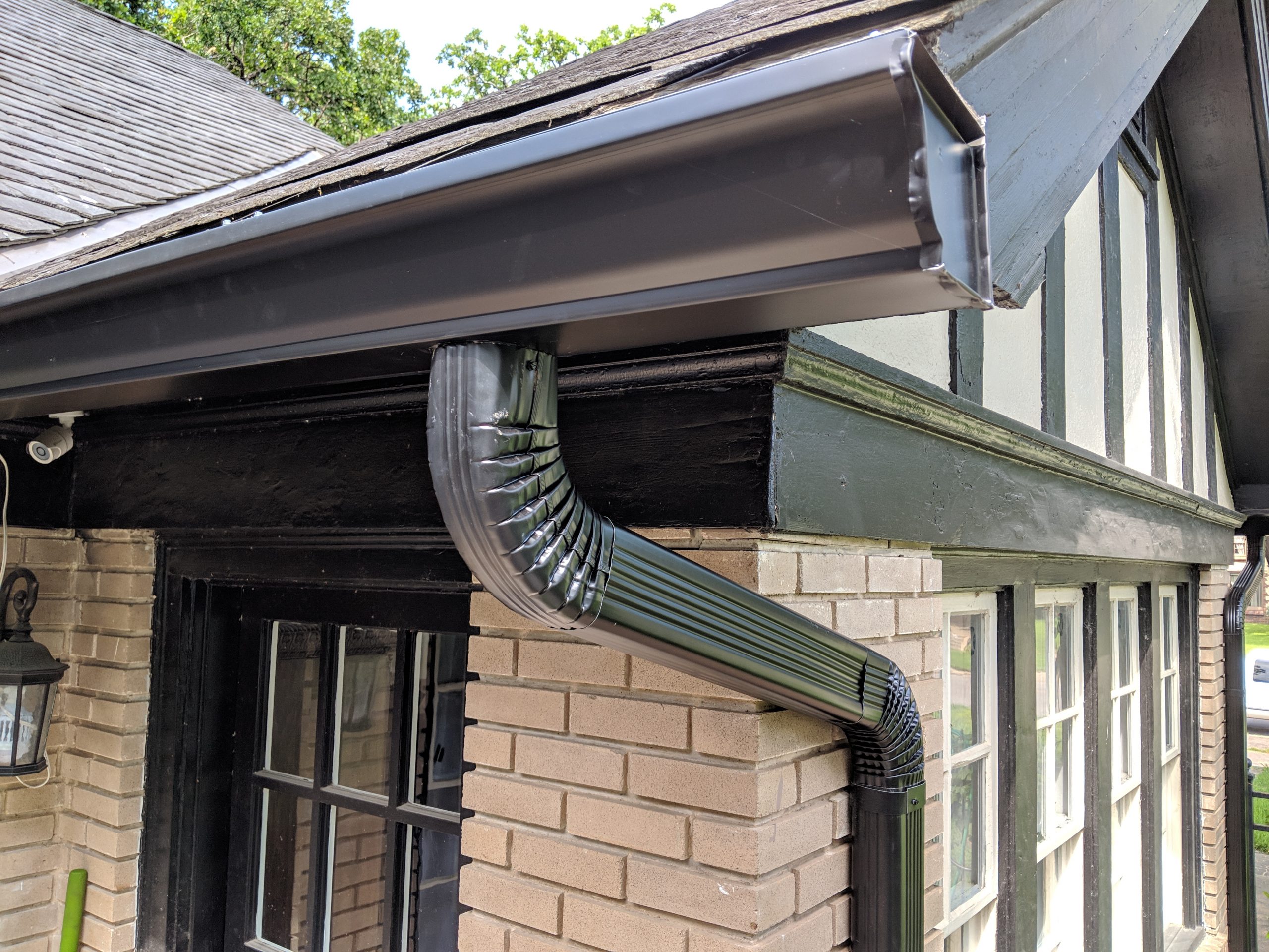 Custom gutter and downspout installation on Tudor-style home
