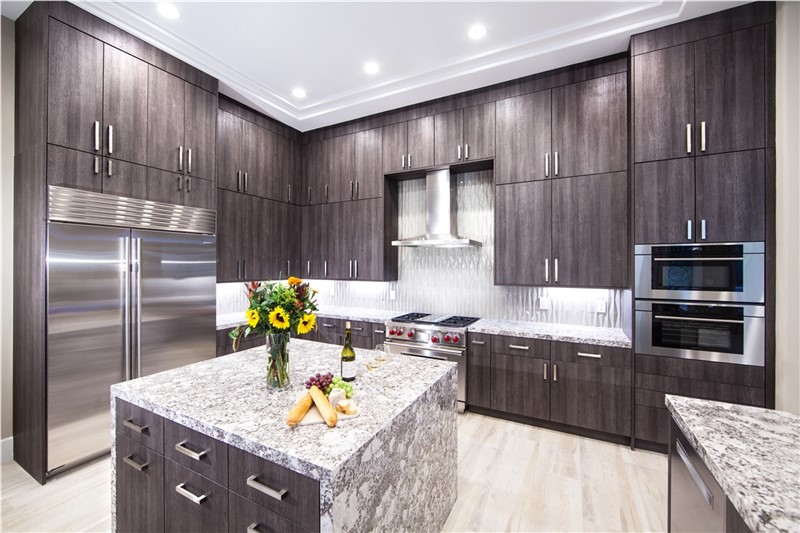 Contemporary dark cabinet kitchen with granite island and stainless appliances