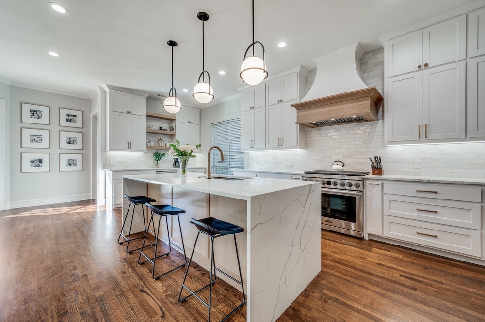 White shaker kitchen with marble waterfall island and pendant lighting