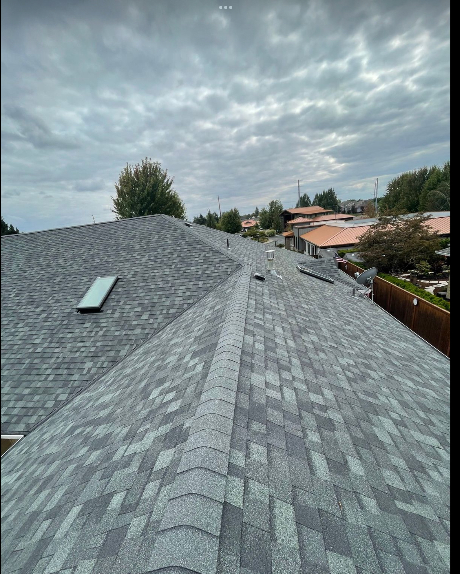 Completed architectural shingle roof with skylight integration